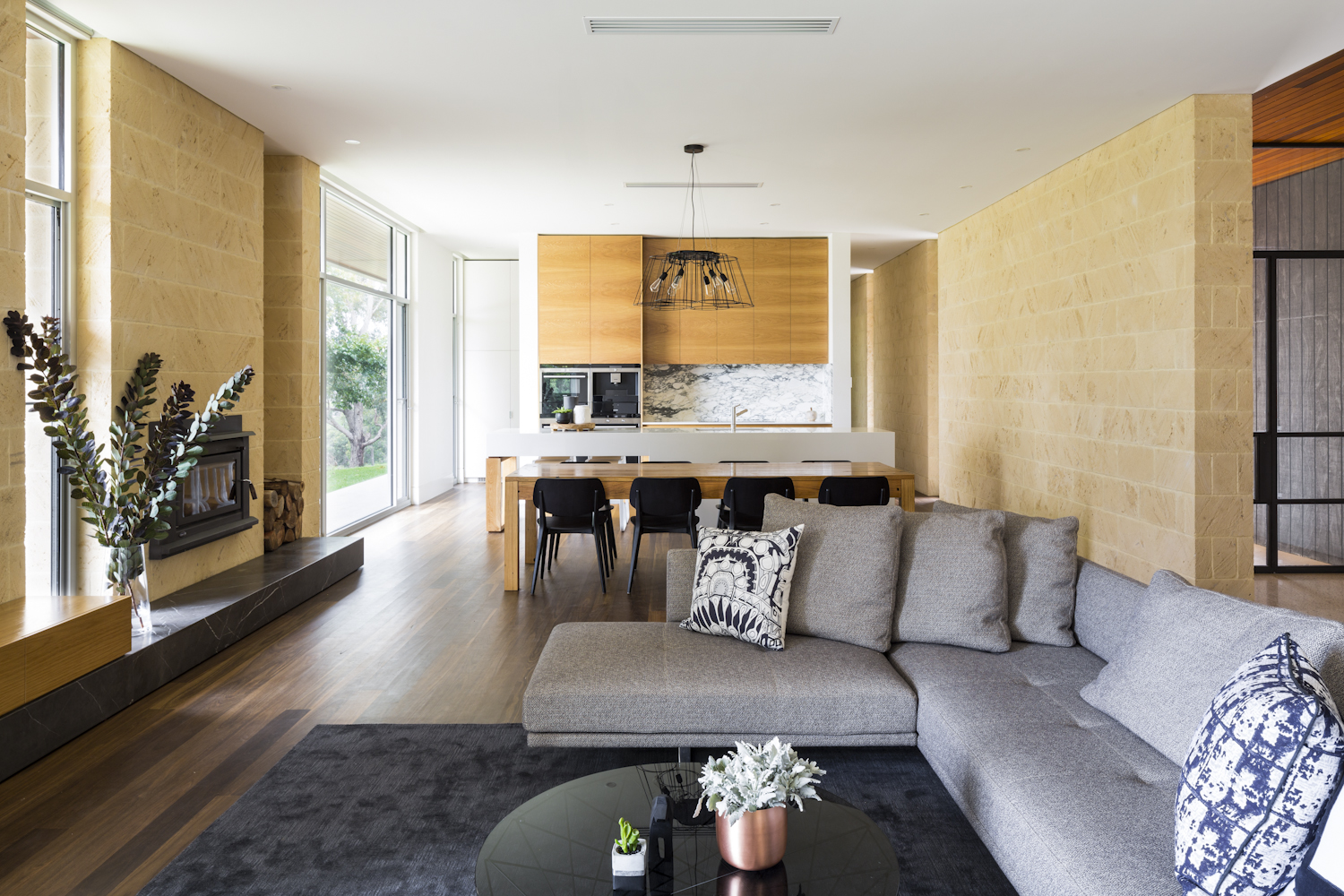 Open plan living and kitchen with limestone feature walls